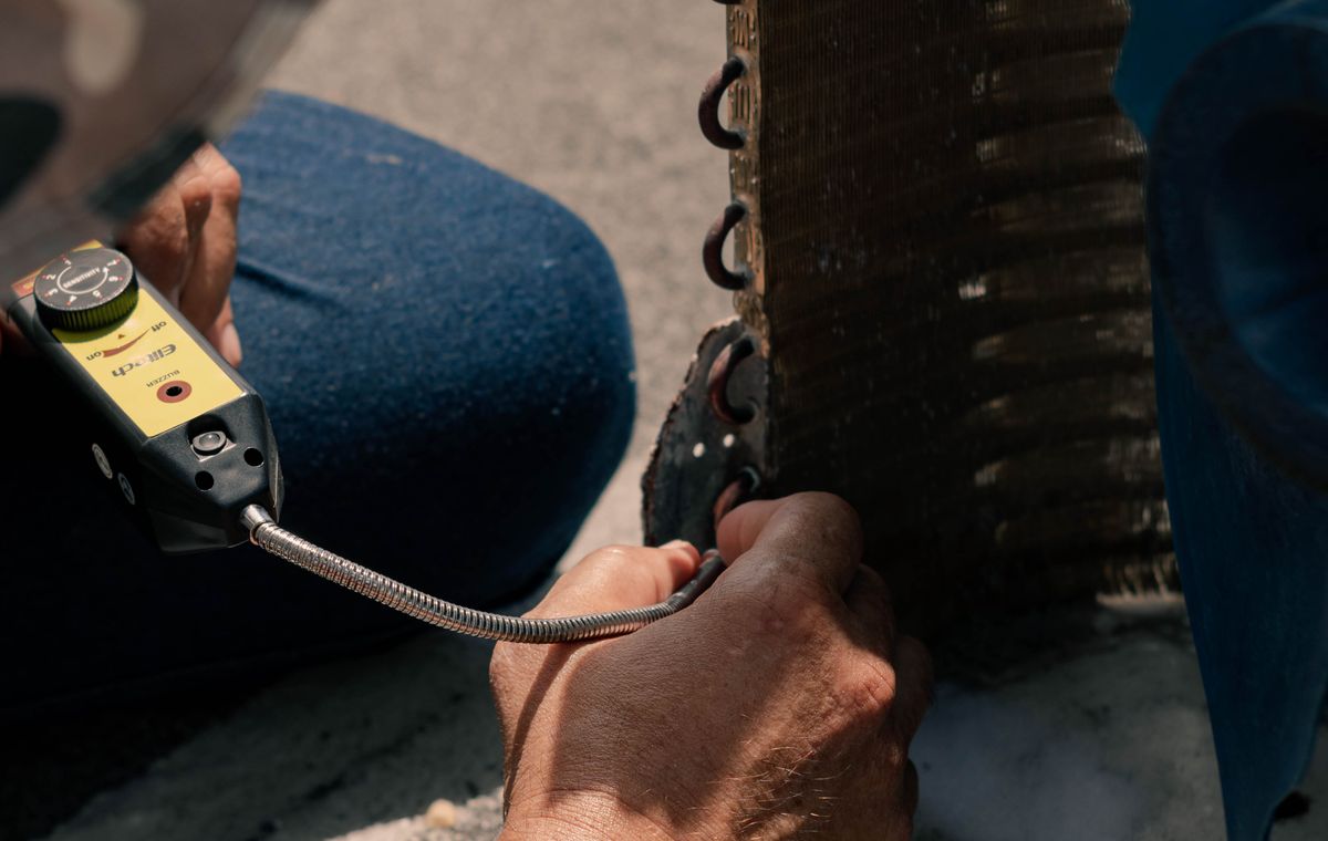 Técnico a verificar um equipamento de climatização