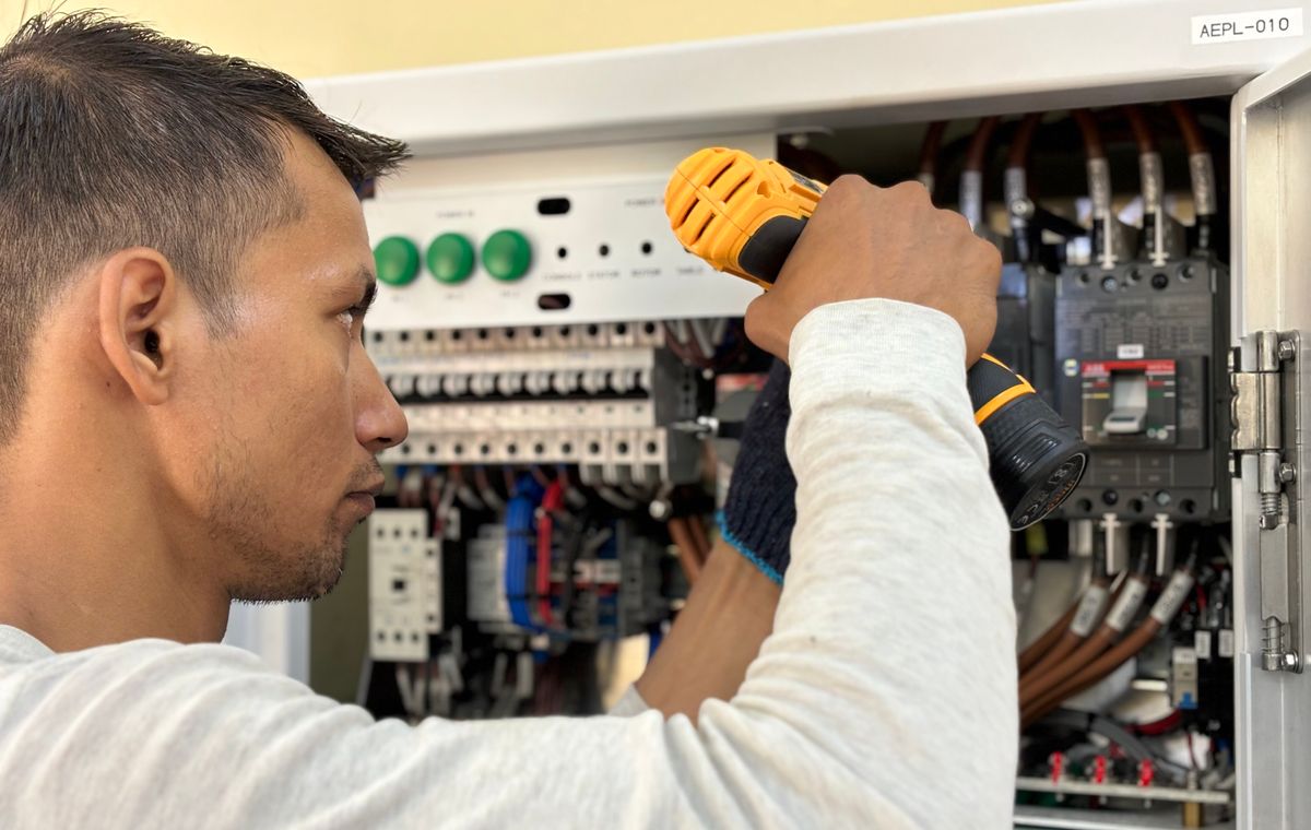 Eletricista a trabalhar num quadro elétrico